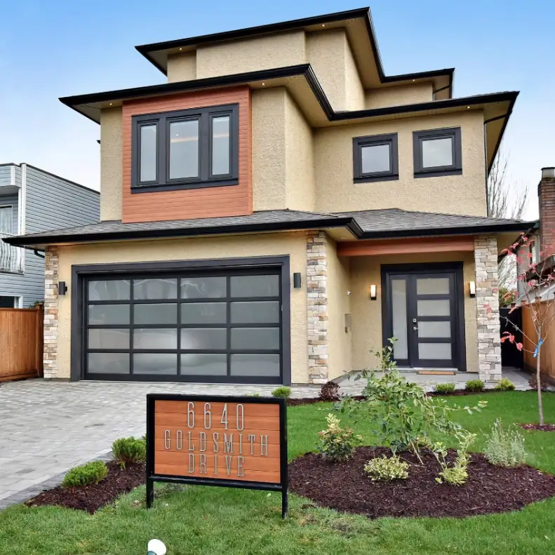 A contemporary custom home with a cedar-toned garage panel and a stone-faced entry.