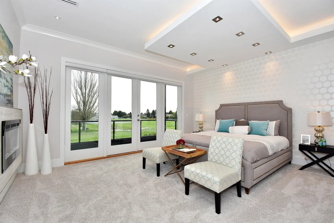 A finished lower-level room, carpeted, lit and ready to furnish.
